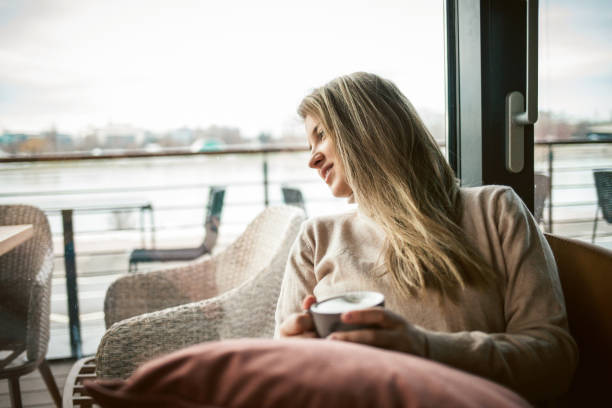 istock young woman drinking coffee at the cafe, looking away 1300018111
