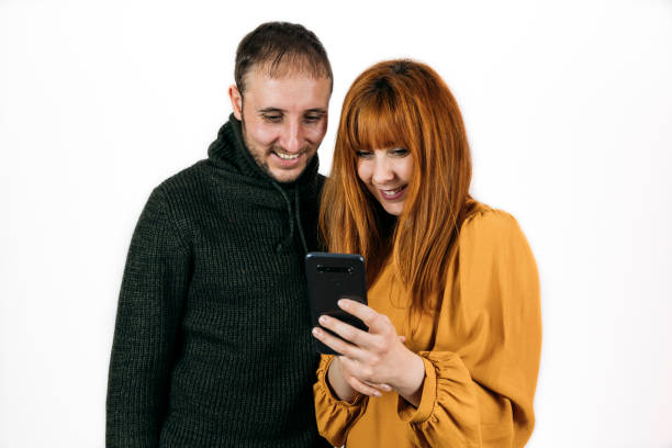 istock Happy couple looking at the phone on white background 1300019082