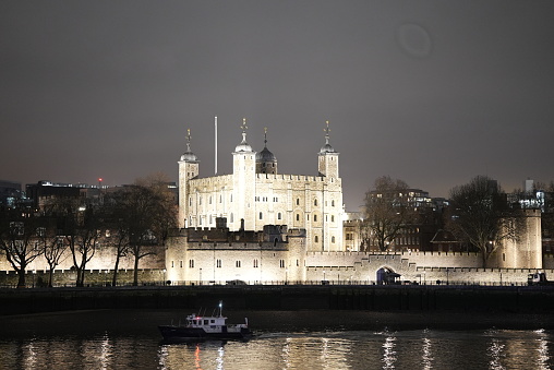 Tower of London at night from the Southbank close to Tower Bridge. This is one of London's most famous landmarks with the River Thames in the foreground.