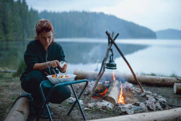 istock Young Woman Is Cooking  Is Next To The Campfire 1300021026