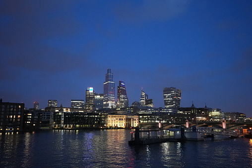 City of London skyline at night from the millenium Bridge looking north east. Visible are the City of London's famous cluster of skyscrapers