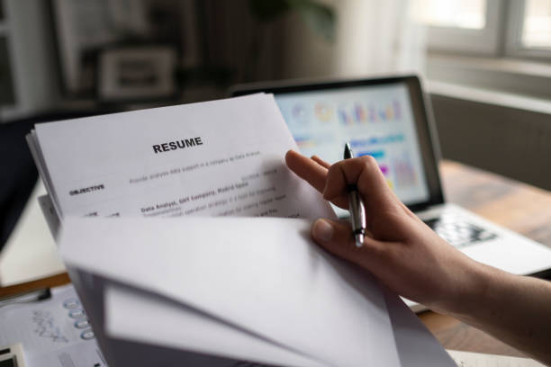istock Man holding resume application with using computer laptop digital to job search on internet. applying for a job concept. 1300024571