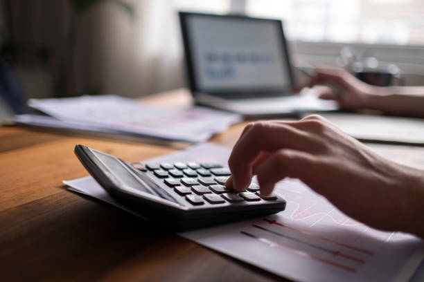 koncepcja rachunkowości biznesowej, człowiek biznesu za pomocą kalkulatora z laptopem komputerowym, budżet i papier pożyczkowy w biurze. - kalkulator zdjęcia i obrazy z banku zdjęć