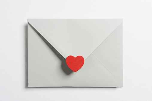 Envelope and heart shape on White background.\nHorizontal composition with copy space.\nValentine’s day concept.