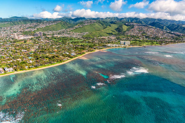 The coastal suburbs of Honolulu, Hawaii shot from an altitude of about 1000 feet over the Pacific Ocean.