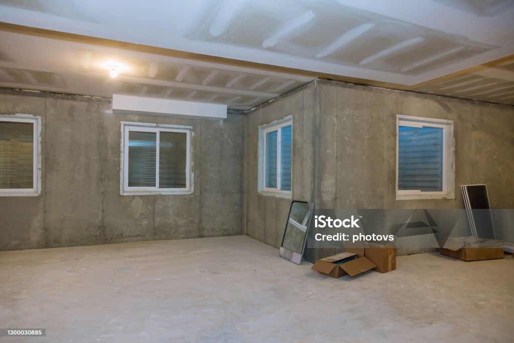 Unfinished view on concrete floor construction of basement empty under construction of home Unfinished view on concrete floor construction of basement empty under construction of residential home Basement Stock Photo
