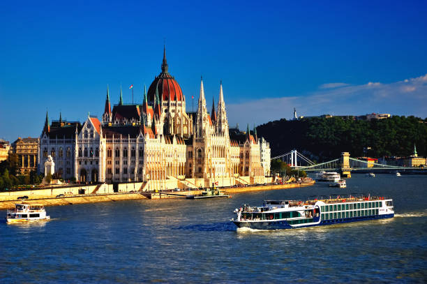 Hungarian Parliament Bldg., Budapest Tourboats cruising up the River Danube. budapest danube river cruise hungary stock pictures, royalty-free photos & images