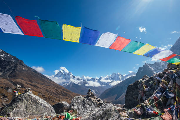 istock Holy buddhist praying multicolored flags with mantras flapping and waving on the strong wind with valley view and Ama Dablam 6812m peak.Everest Base Camp trekking route near Dughla 4620m. 1300033090