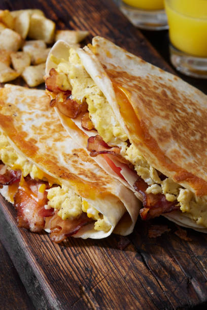 istock The Folded Breakfast Tortilla with Scrambled Eggs, Bacon, Tomato and Cheese 1300035926