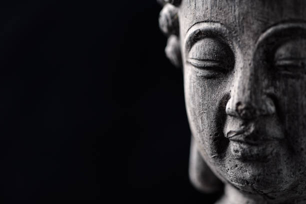 istock Meditating Buddha Statue isolated on black background. Copy space. 1300036446