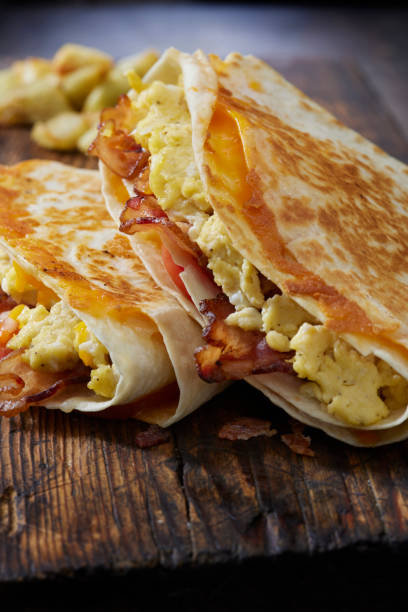 istock The Folded Breakfast Tortilla with Scrambled Eggs, Bacon, Tomato and Cheese 1300036597