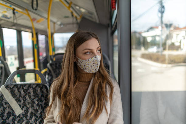 istock Young woman with protective face mask using public transportation during covid-19 pandemic 1300036664