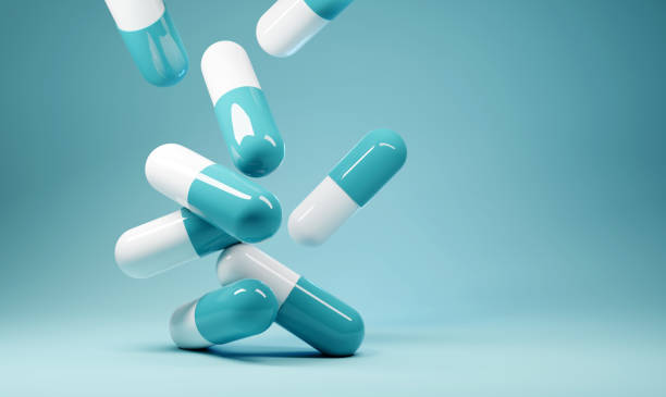 Falling Antibiotics Healthcare Background A group of antibiotic pill capsules fallling. Healthcare and medical 3D illustration background. painkiller stock pictures, royalty-free photos & images