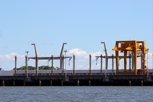 industrial infrastructure of seaport, sea, cranes and dry cargo ship, grain silo, bulk carrier vessel and grain storage elevators, concept of sea cargo transportation