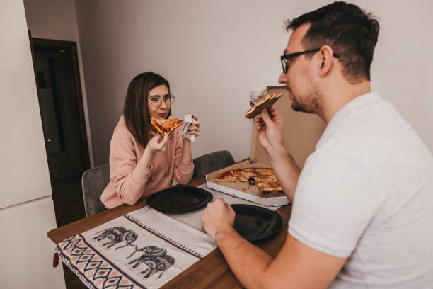 istock Couple eating pizza at home 1300041021