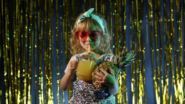 bambino alla moda con succo di frutta all'ananas in un club futuristico con luce al neon - girl sunglasses 80s foto e immagini stock