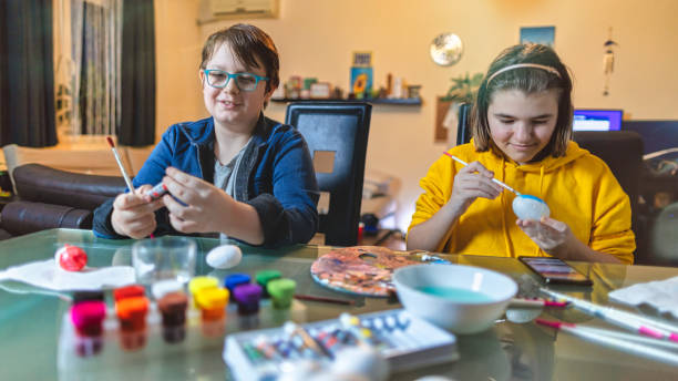 istock Boy and Girl Painting an Easter eggs 1300044805