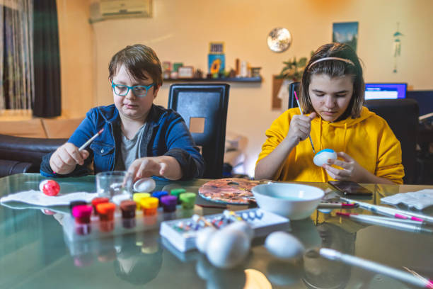 istock Boy and Girl Painting an Easter eggs 1300044812