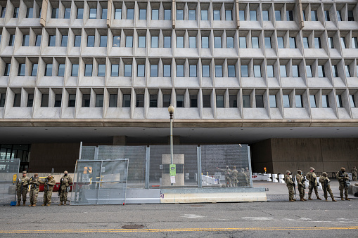 Washington DC, USA - January 18, 2021: Armed members of the National Guard provide security in Washington DC, here standing on 3rd St SW outside the US Department of Health and Human Services.