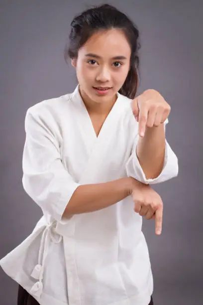 woman fighter portrait; asian woman practicing chinese martial arts, gongfu, kungfu, taichi, taiji, MMA studio isolated portrait; girl fighter training concept; 20s young adult asian woman model