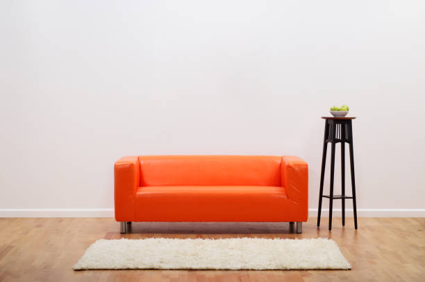 Barren Room with Blank White Wall and orange couch This is a photograph of Barren Room with Blank White Wall and orange couch shag rug stock pictures, royalty-free photos & images