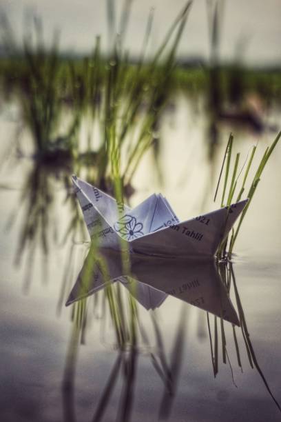 istock Paper boat in the river 1300050681
