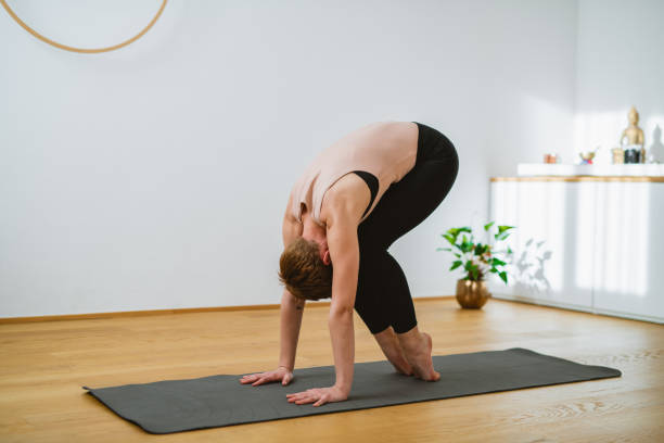 istock Woman in Early 30s Holding Standing Forward Fold Pose 1300053055