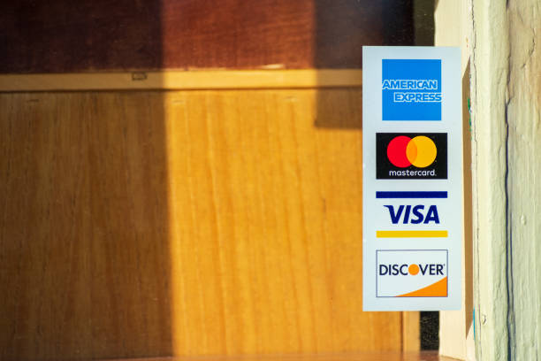 American Express, MasterCard, VISA, Discover decals on restaurant door American Express, MasterCard, VISA, Discover payment options advertised on a restaurant door - San Francisco, California, USA - 2020 american express stock pictures, royalty-free photos & images