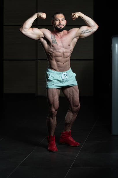 istock Muscular Men Is Hitting Rear Double Bicep Pose 1300054416