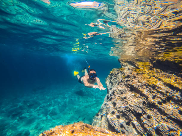 istock Men snorkeling by the reef 1300056519