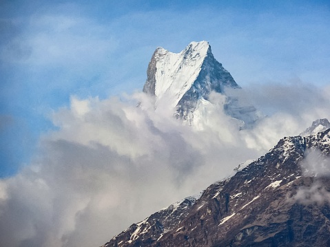 Photo of Mount Machapuchare shrouded by the clouds. Photo taken on the Annapurna Base Camp Trek in Nepal.