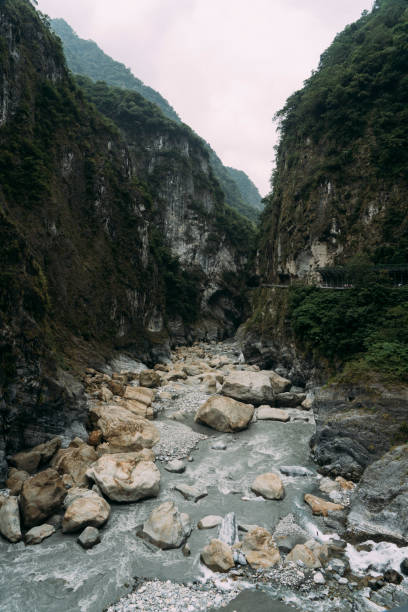 istock Stony river bed with epic steep cliffs on each side in Taroko National Park. 1300062475