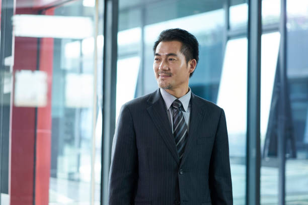 istock asian manager walking in company hallway 1300066570