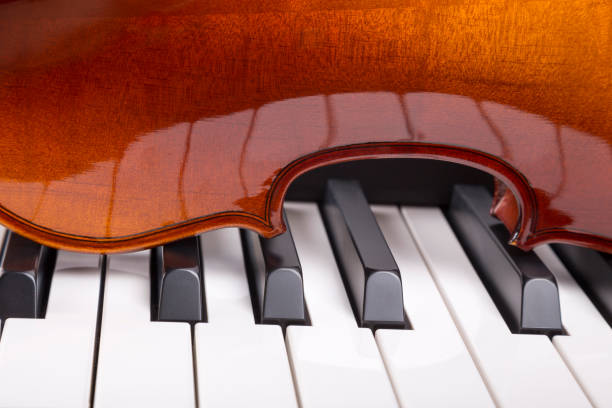 istock Piano keys are reflected in the violin fragment 1300067393