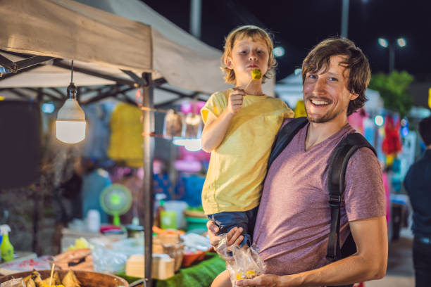 Dad and son are tourists on Walking street Asian food market Dad and son are tourists on Walking street Asian food market. chiang mai province stock pictures, royalty-free photos & images