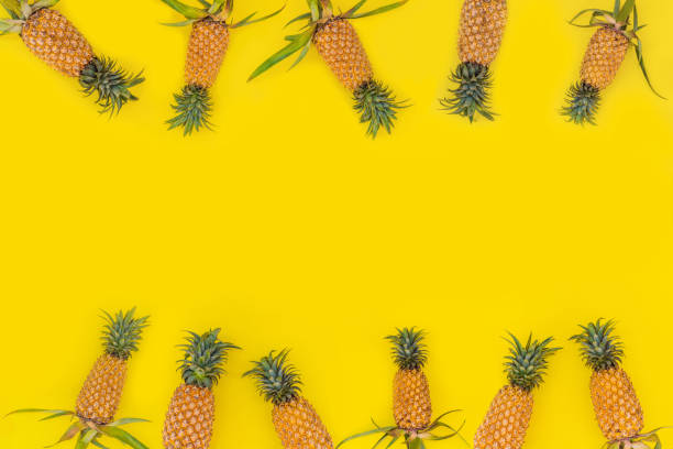 istock Pattern with bright pineapples on yellow background. Top View. Copy Space. Minimal style. Pop art design, creative summer concept. Banner 1300068399