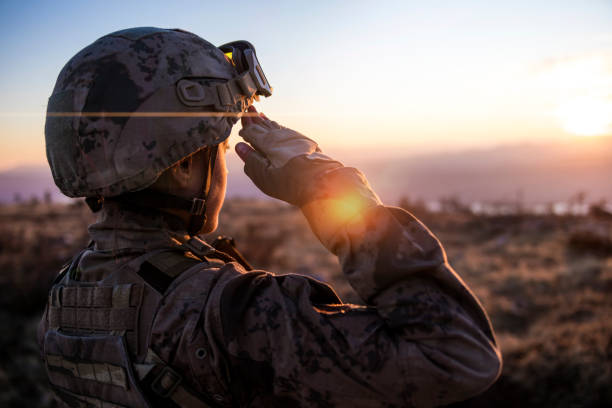 solider femelle d’armée saluant contre le ciel de coucher du soleil - soldat photos et images de collection