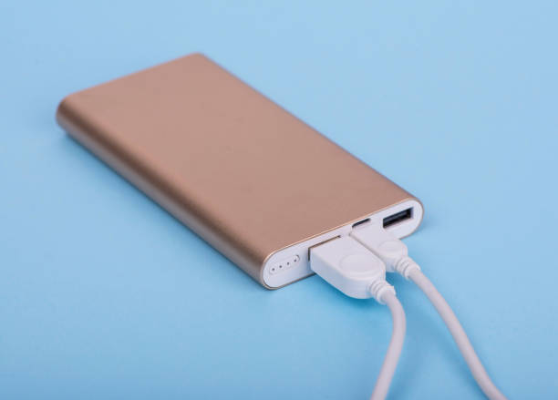 istock Smartphone charging with power bank on a blue background 1300073288