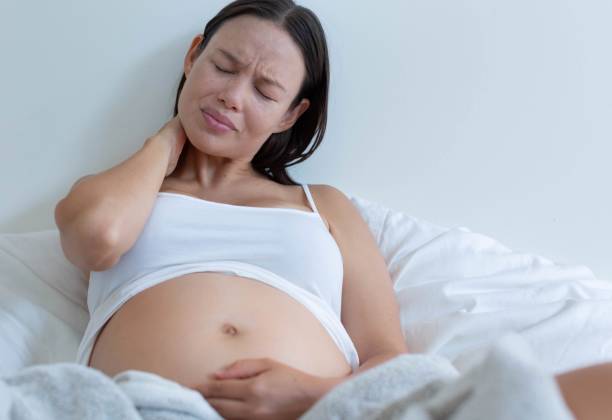 istock A pregnant woman suffering from a sore neck and back. 1300073404