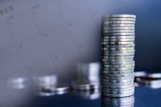 istock Future plan saving money for 2021 year concept. double exposure of stack coins with calendar on dark black background. 1300077564