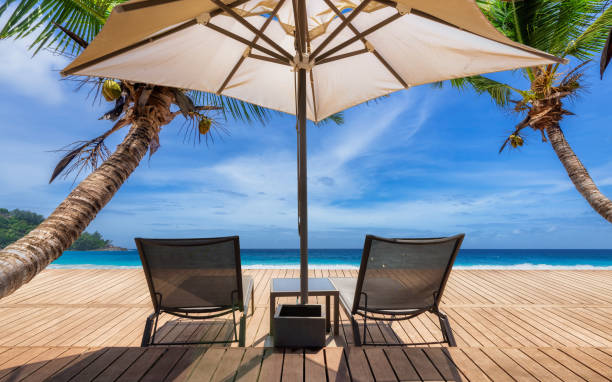 istock Beach umbrella and beach chairs on tropical beach 1300077622