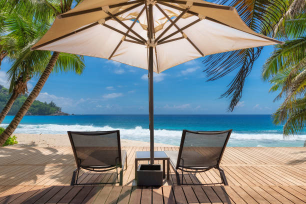 istock Beach umbrella and beach chairs on tropical beach 1300077746