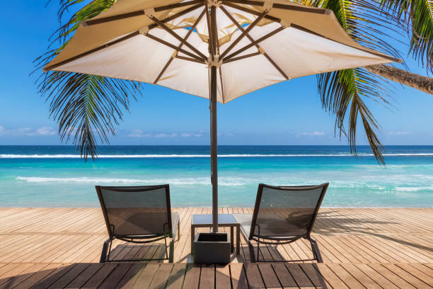 istock Beach umbrella and beach chairs on tropical beach 1300077753
