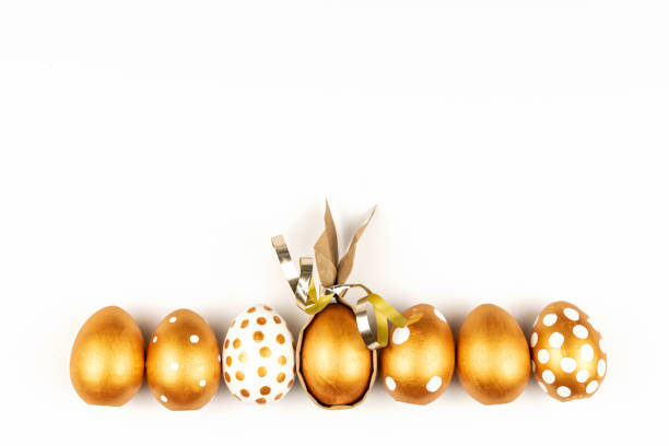 istock Easter festive decoration.Top view of easter eggs colored with golden paint on white background. Various dotted designs 1300078056