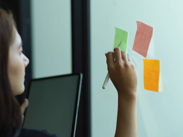 istock Female office worker working with digital tablet and sticky note with idea in office room 1300078095