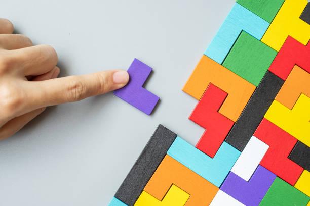 istock hand connecting geometric shape block with colorful wood puzzle pieces. logical thinking, business logic, Conundrum, decision, solutions, rational, mission, success, goals and strategy concepts 1300078681