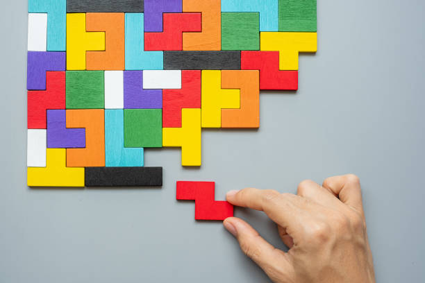 istock hand connecting geometric shape block with colorful wood puzzle pieces. logical thinking, business logic, Conundrum, decision, solutions, rational, mission, success, goals and strategy concepts 1300078682