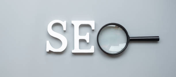 istock SEO (Search Engine Optimization) text and magnifying glass on gray background. Idea, Vision, Strategy, Analysis, Keyword and Content concept 1300078852