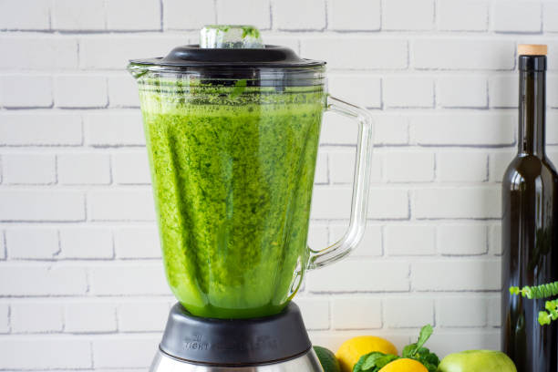 proces przygotowania zielonego smoothie w blenderze kuchennym. - blender salad lemon vegetable zdjęcia i obrazy z banku zdjęć