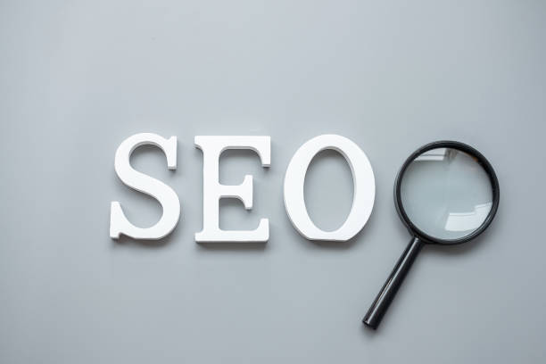 istock SEO (Search Engine Optimization) text and magnifying glass on gray background. Idea, Vision, Strategy, Analysis, Keyword and Content concept 1300079032